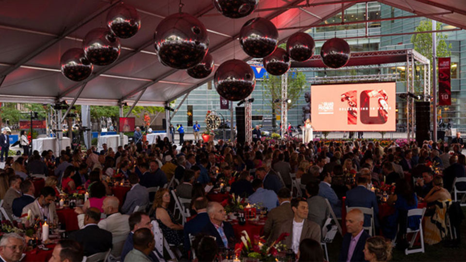 A wide look at the 2024 PwC Grand Prixmiere dinner with many people at tables