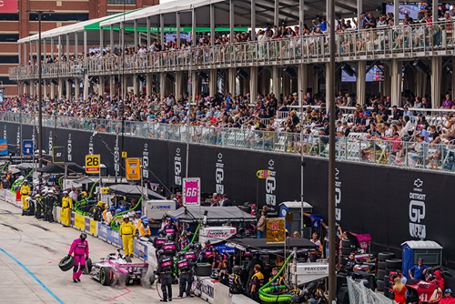 A car during a pit stop with fans in the Pit Lane Suites watching in the background