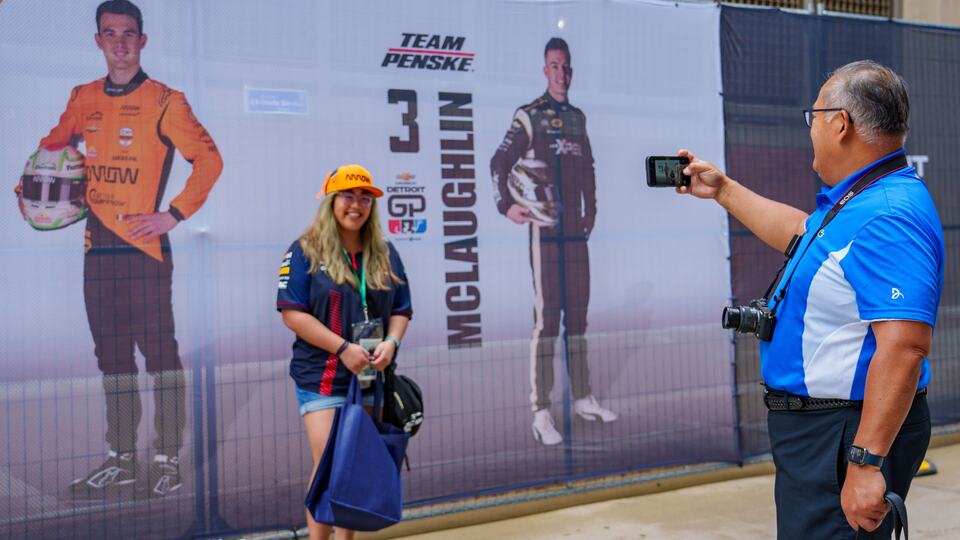A fan takes a photo with photos of drivers